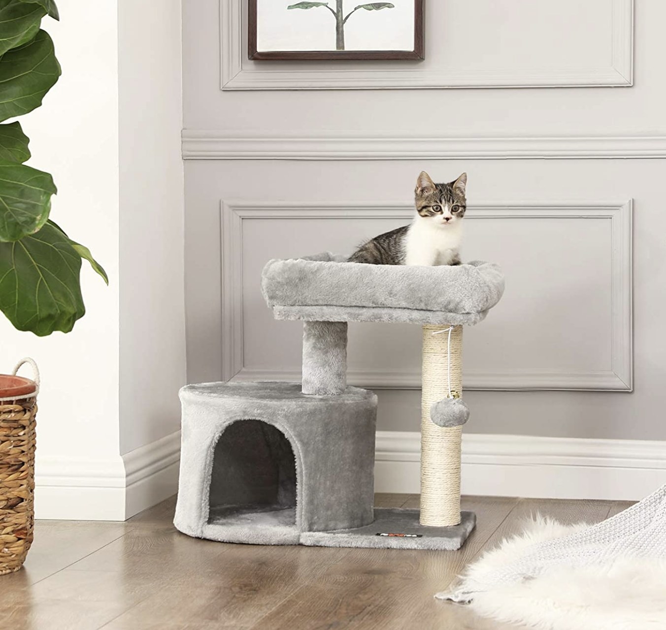 a can with stripes sitting on top of a cat tree that is grey with an ivory scratch post