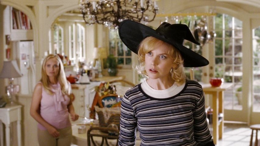 Nicole Kidman as Samantha wearing a witch hat in her kitchen
