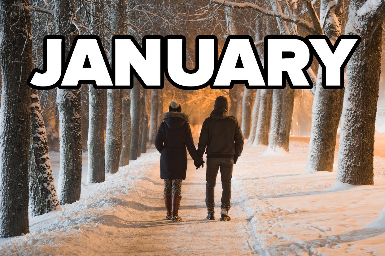 A couple holding hands and walking down a snowy path