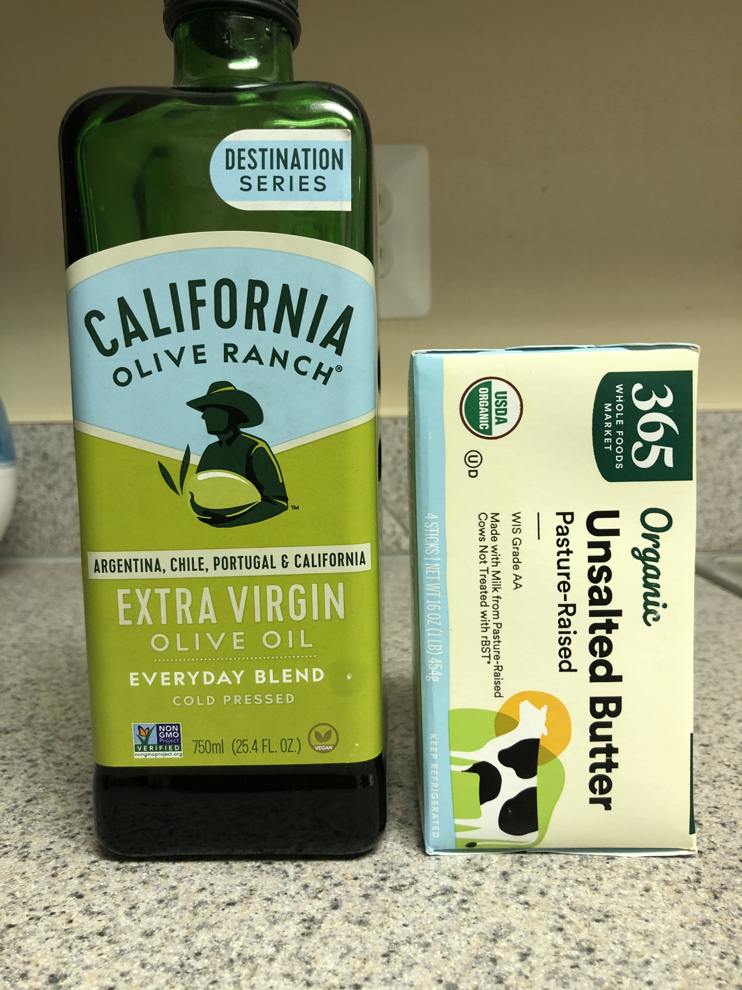 A bottle of extra virgin olive oil next to organic butter