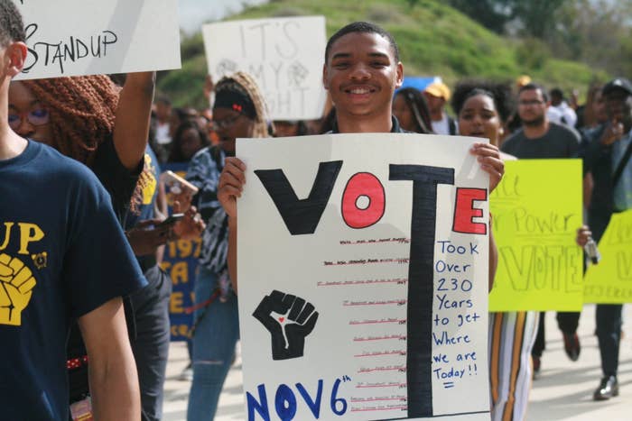 Students hold signs in a protest that say "Vote"