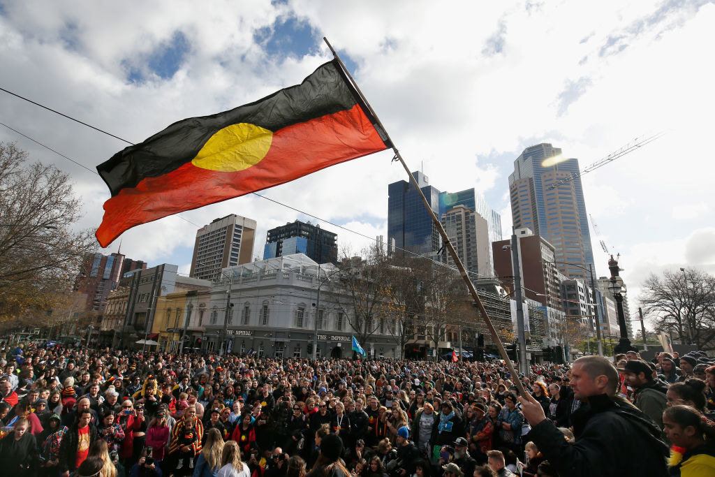 Protesters at a Black Lives Matter rally in Australia; the Aboriginal flag is being held up by a man