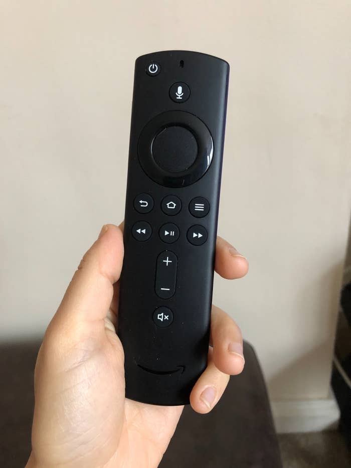 Jasmin holding the Fire TV Stick remote in their hand