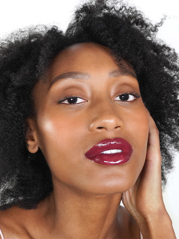 Model wearing the lip gloss in rich plum shade