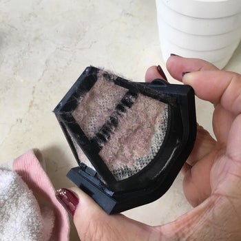 Reviewer holding the filter, which is covered in dust