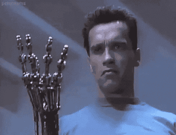 Gif of Arnold Schwarzenegger flexing his robotic hand in The Terminator