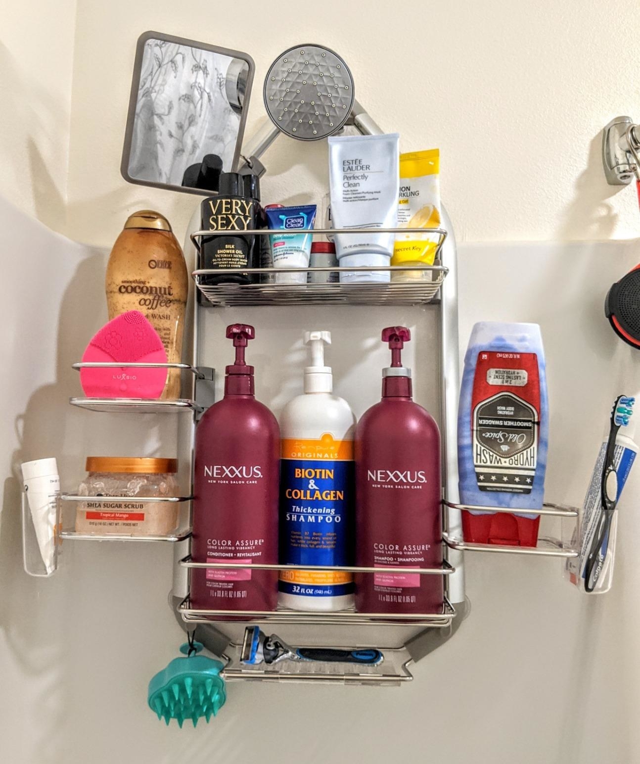 Reviewer photo of the shelf holding several bottles of shampoo, conditioner, body wash,  razors, a toothbrush, toothpaste, and more
