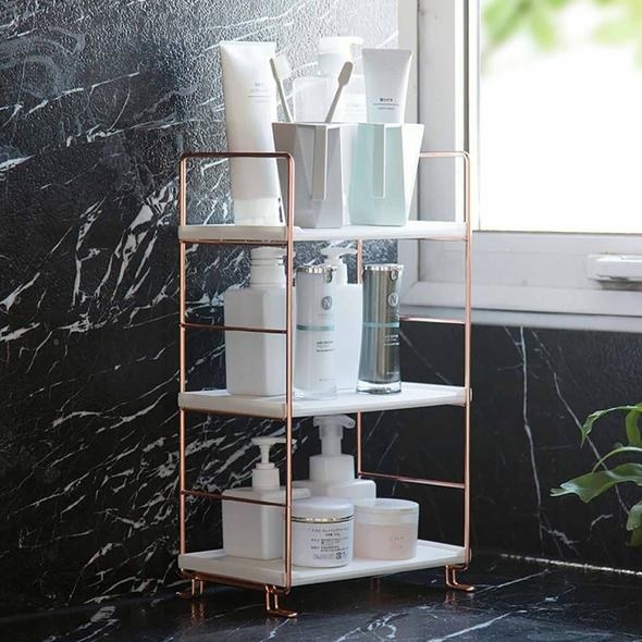 The three-tier white shelf with rose gold accents