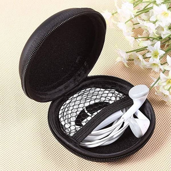 Black carrying case with white earphones in it.