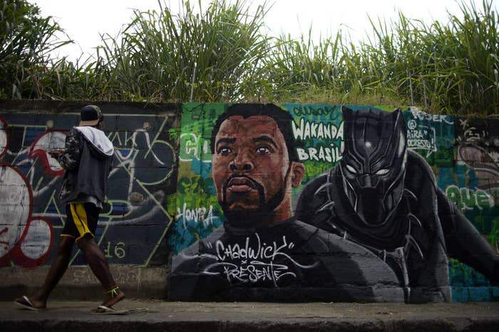 A passer-by looks at a mural painting in honor of the late actor Chadwick Boseman