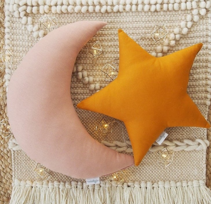 The moon and star pillows on top of a macrame rug