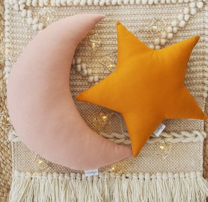 The moon and star pillows on top of a macrame rug