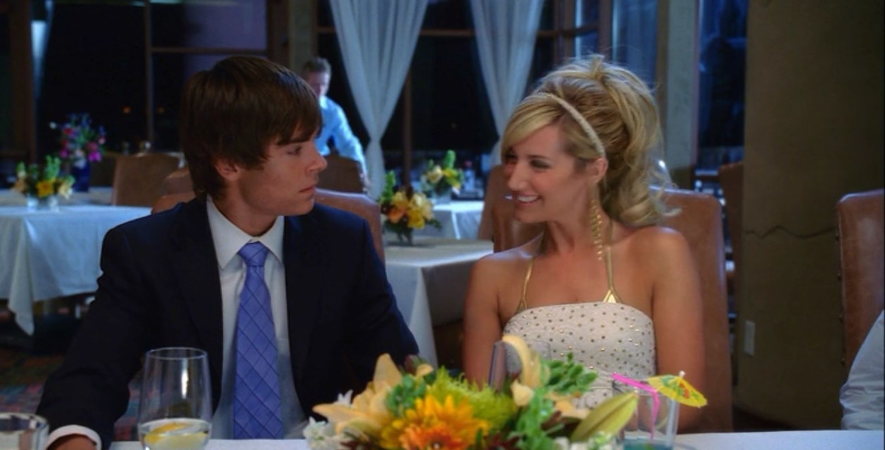 Sharpay smiling at Troy at a fancy dinner party and he looks uncomfortable 