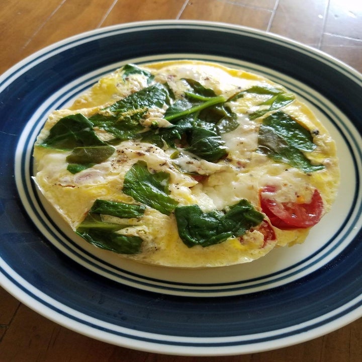 Reviewer photo of their omelette with spinach and tomatoes