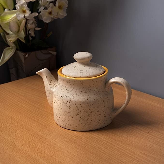 White ceramic kettle with a marble finish and a yellow rim.