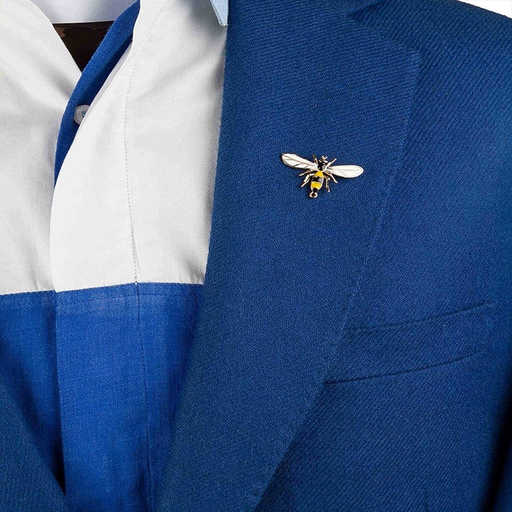 The brooch pinned to the lapel of a blue blazer.