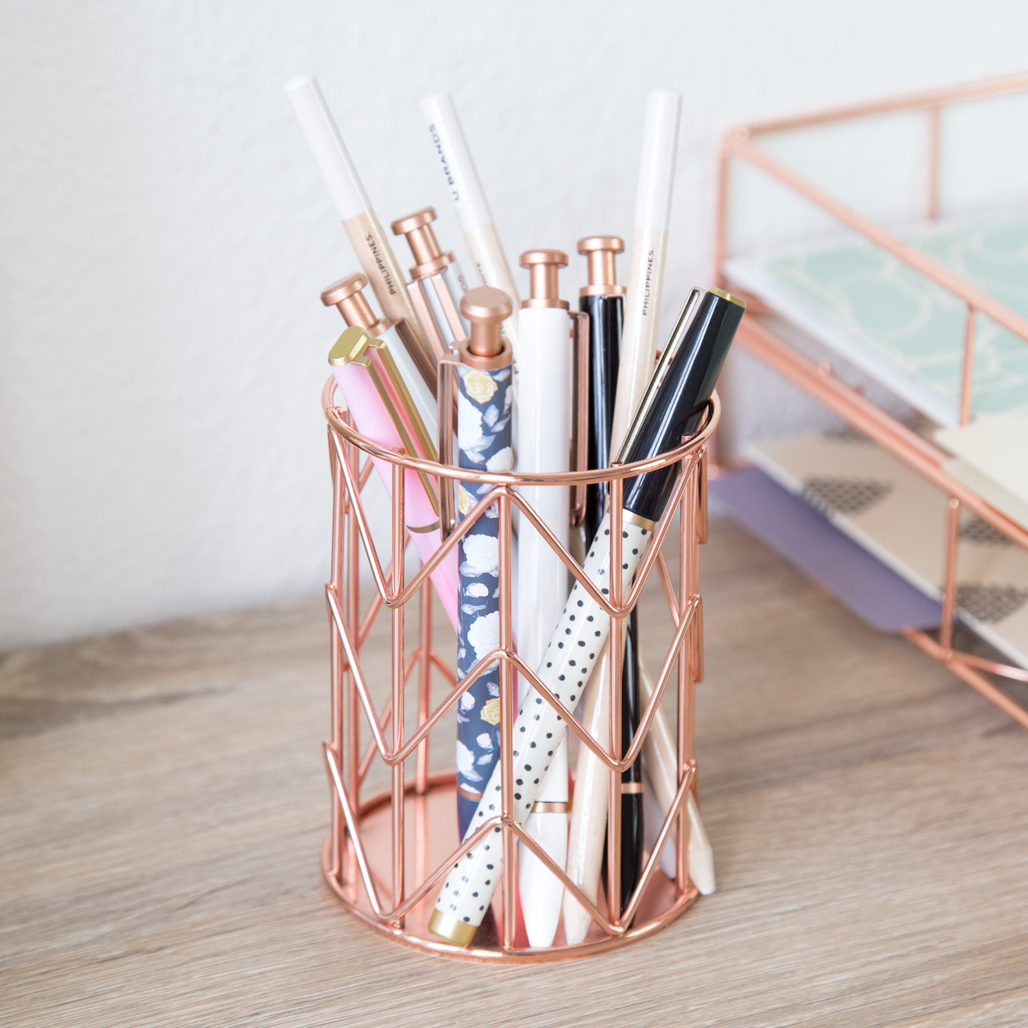 An open rose gold pencil cup with pencils in it