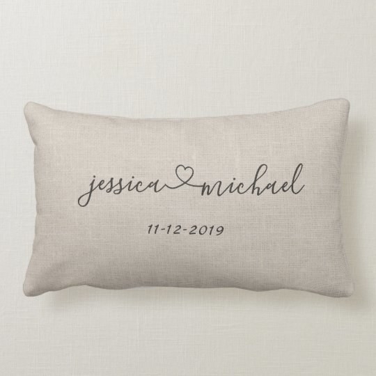 a tan lumbar pillow with jessica heart sign michael on it and a date beneath the script