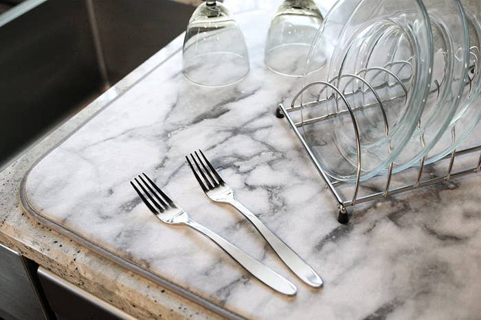 A marble dish towel with cutlery and dishes on it