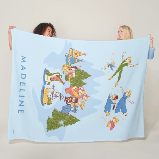 two models holding up a light blue blanket with peter pan characters on it