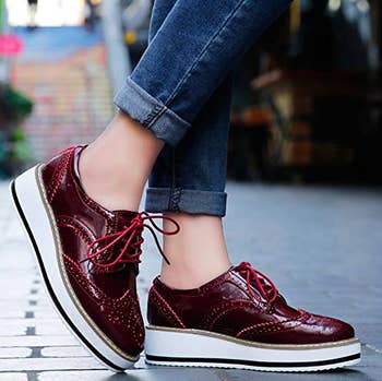 Model wears red oxford platform shoes with cuffed jeans