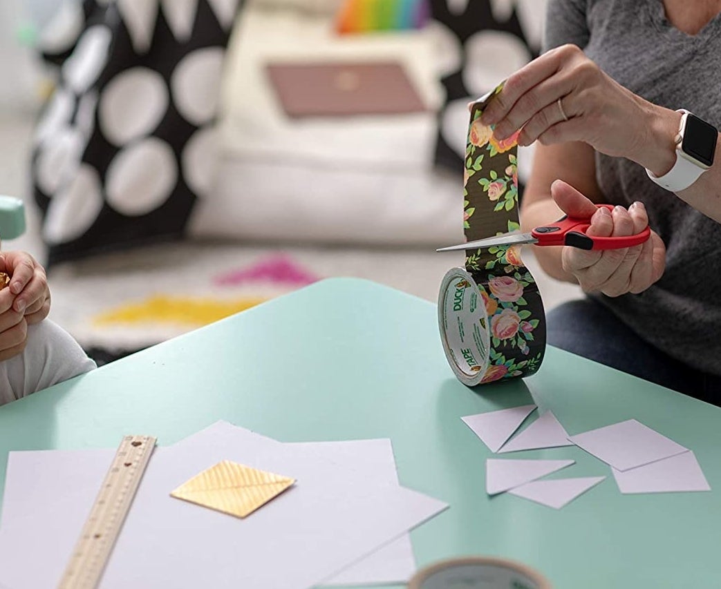 A person cuts floral duct tape