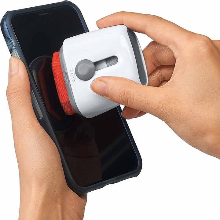 A person using the screen cleaner on their cell phone