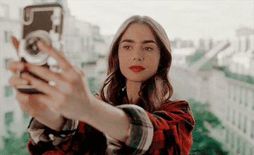 Emily taking a selfie in front of her Parisian view. 