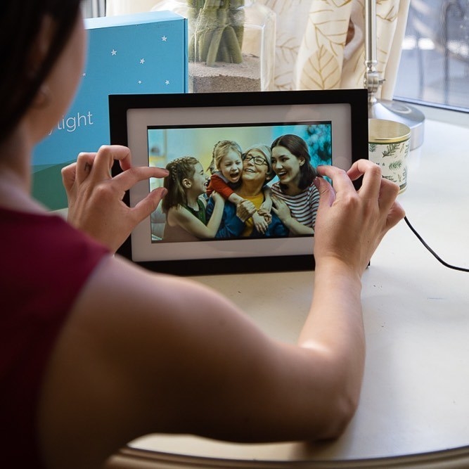 A model adjusting a photo on the touchscreen black frame