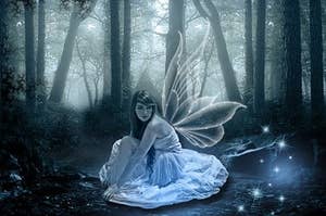 A fairy sitting on the floor with clear wings outside her back. 