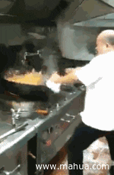 A chef tossing some rice in a large wok in a kitchen.