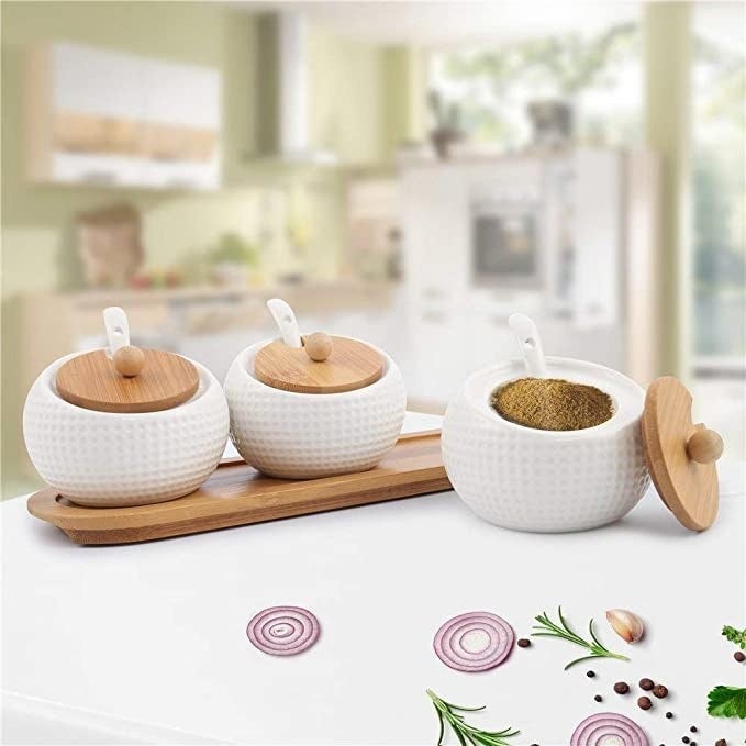 Ceramic jars with wooden lids and a wooden tray.