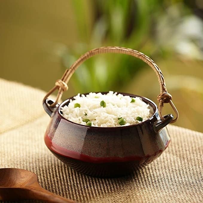 Ceramic bowl with some peas pulao in it.