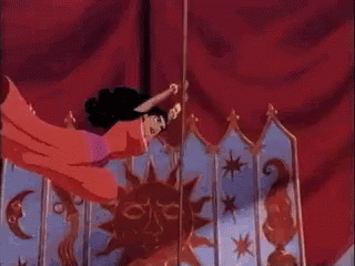 Esmeralda swings around a pole in a red dress and skims the ground