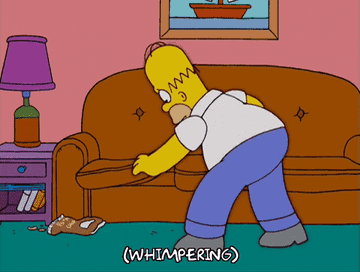 Homer Simpson frantically looking for an object in his couch in the show &quot;The Simpsons.&quot;