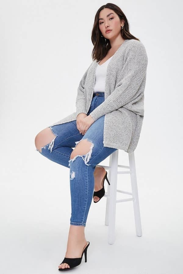 A model wearing the cardigan in the &quot;cream/black&quot; color
