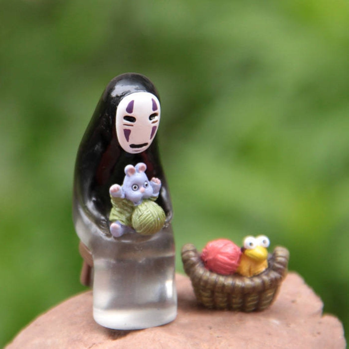 no face from spirited away figure with mouse and yarn in lap and small basket with yarn and the bird that was once a big baby 