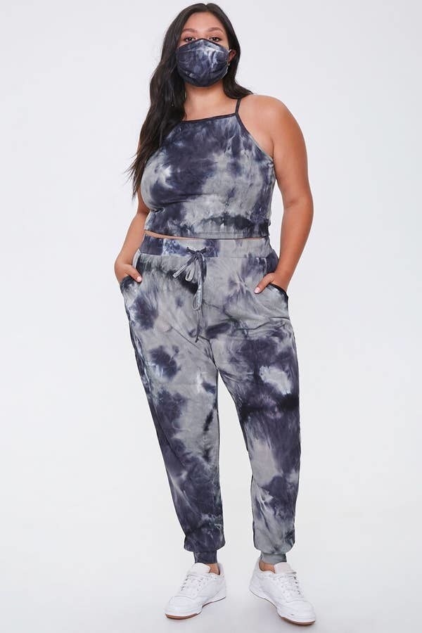 A model wearing the black/cream tie dye pants, tank top, and non medical face mask set