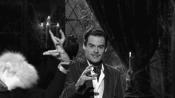 a gif of bill hader as vincent price and kristen wiig making a scary face as judy garland