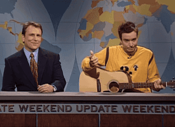a gif of jimmy fallon playing the guitar at the weekend update desk