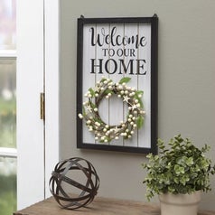 A sign that says "Welcome to our Home" with a hanging summer seashell wreath