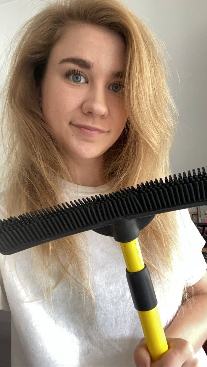 BuzzFeed editor posing with broom 