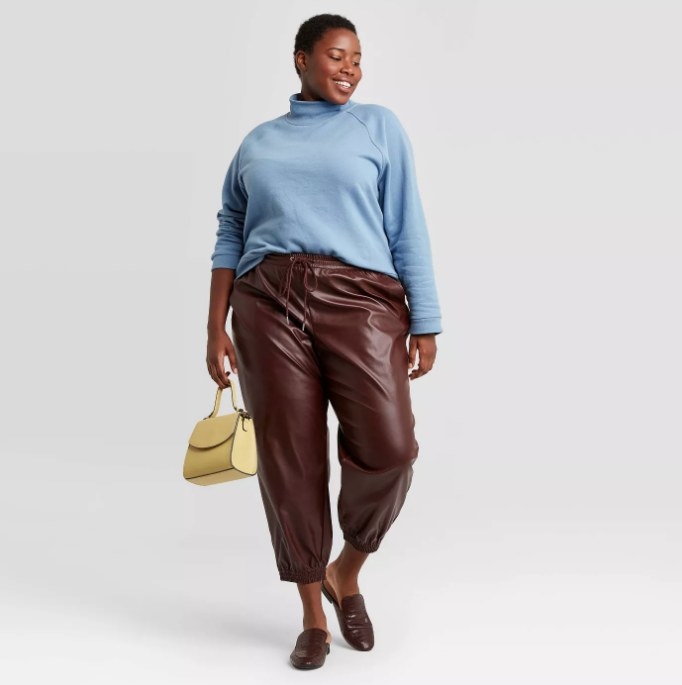 Model wearing leather pants in burgundy