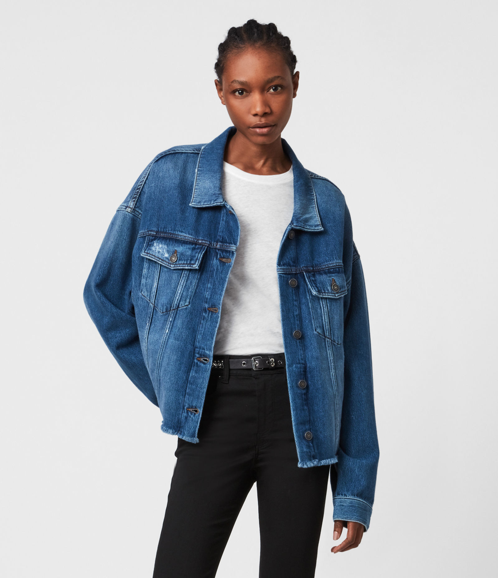 A model in the blue distressed jean jacket with a raw hem