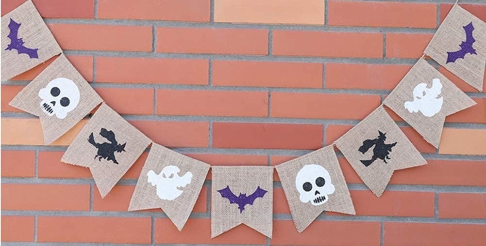 A banner across a brick wall with bats skulls witches and ghosts