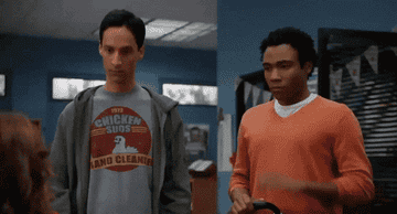 Danny Pudi and Donald Glover as Abed and Troy high-fiving 
