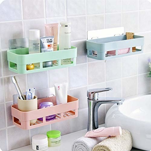 Mint green, baby pink and baby blue bathroom organisers stuck on the wall.