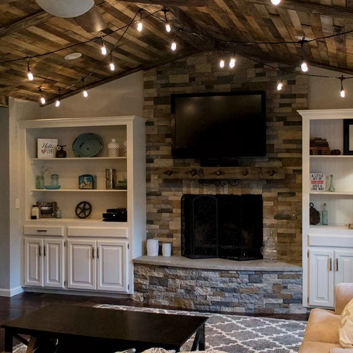 Bistro lights hung above a living room with fireplace