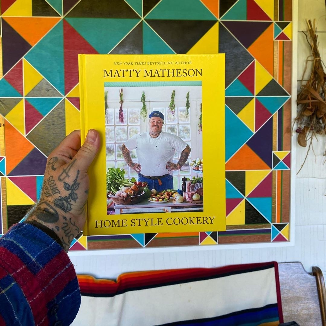 Matty Matheson holding up his cookbook