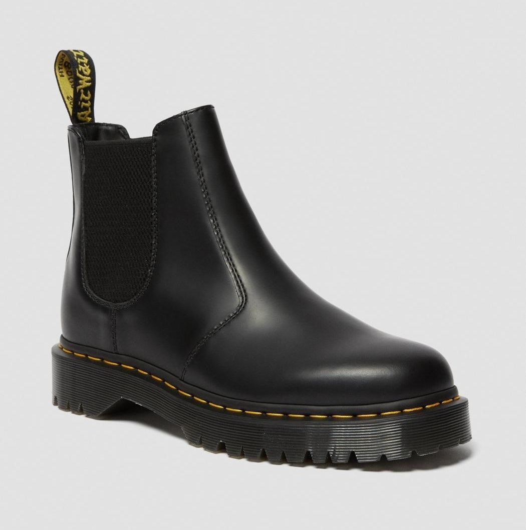 A black pull-on boot with yellow stitching and elastic stretch